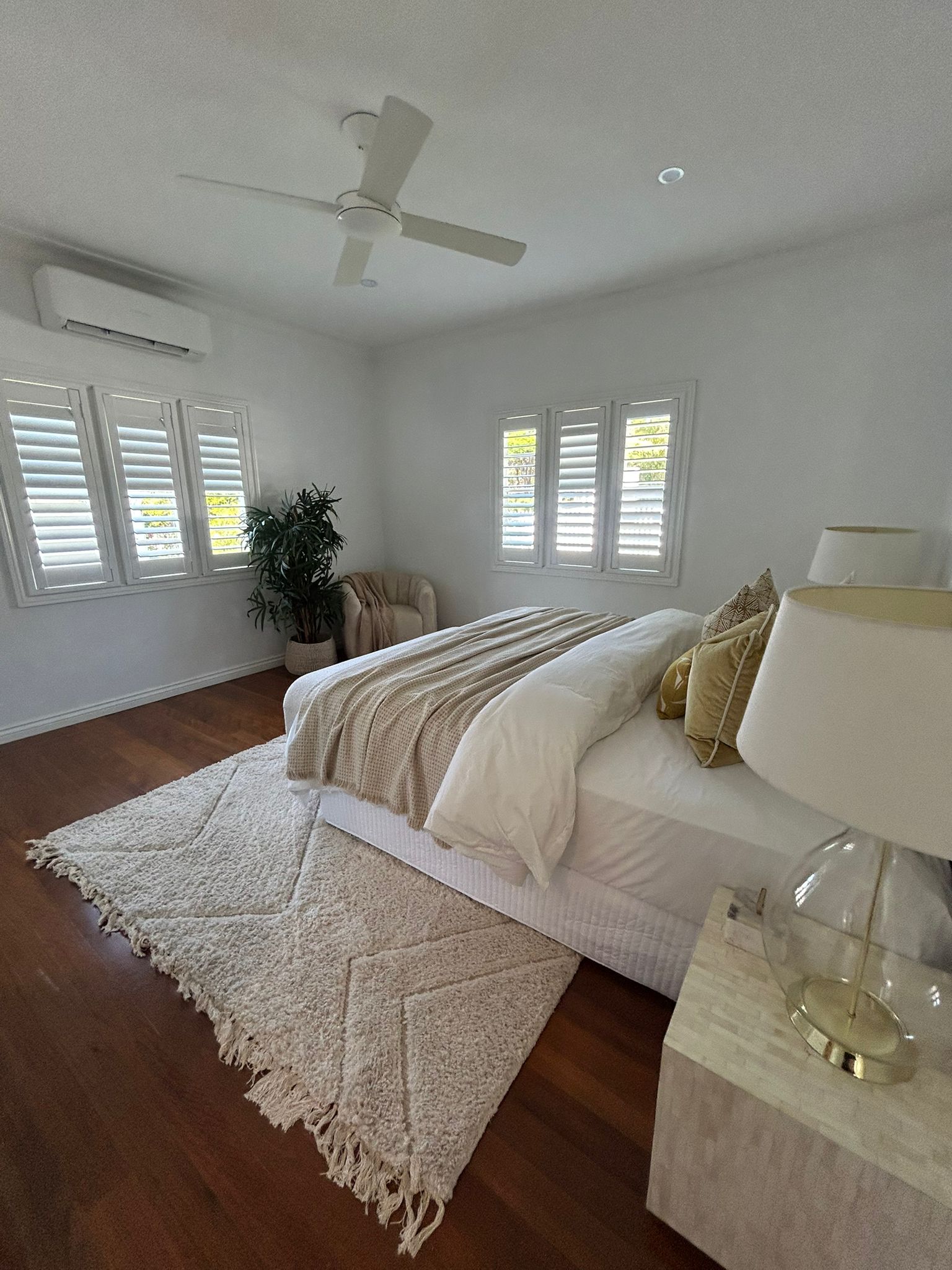 Clean bedroom with plantation shutters and aircon