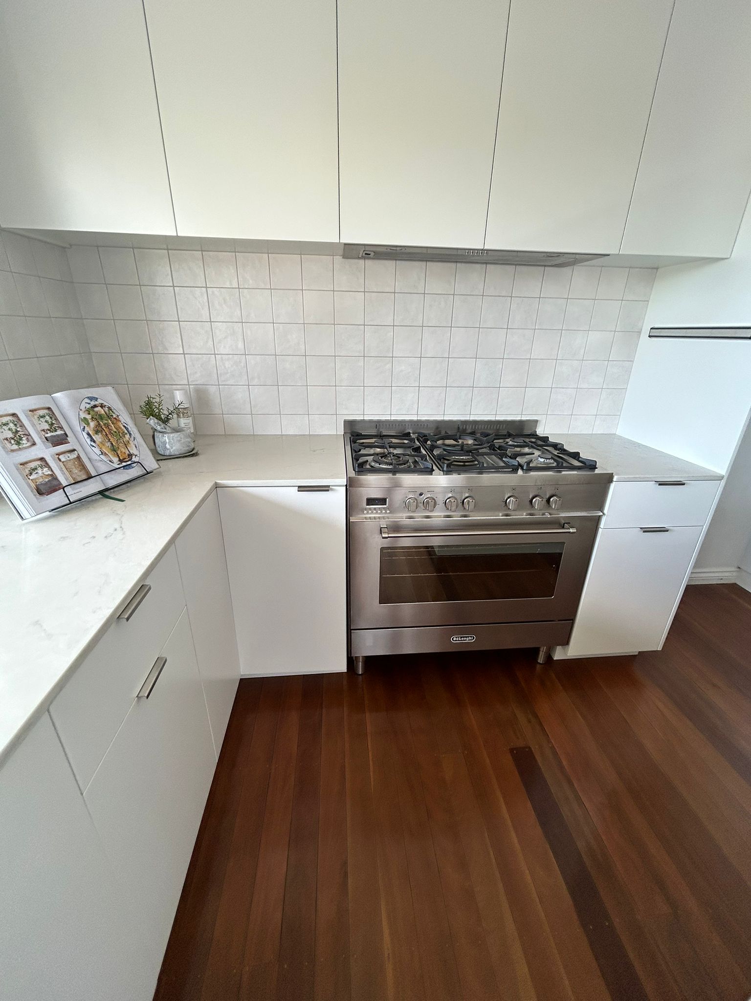 Clean kitchen with stainless oven and white cabinetry